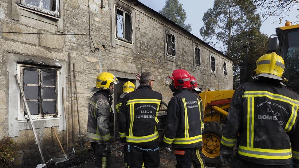 Pompiers devant bâtiment incendié aux fenêtres brûlées