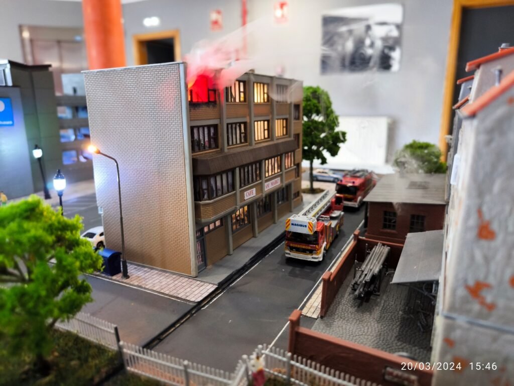 Maquette urbaine avec immeuble en feu et pompiers