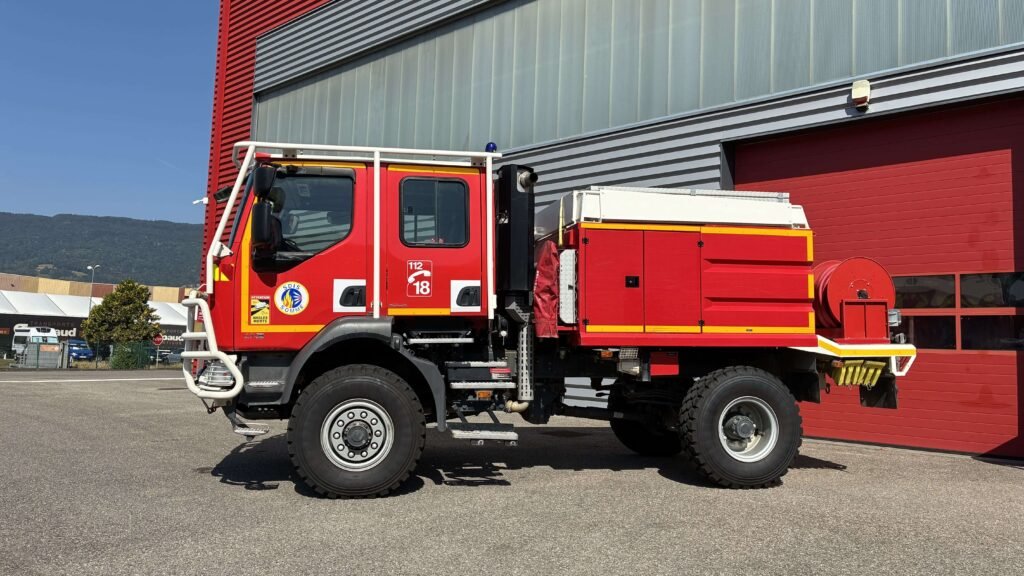 Camion de pompiers rouge devant caserne