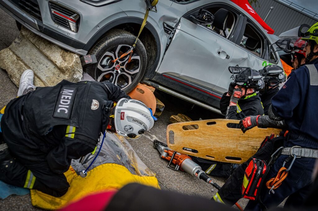 Pompiers secourant victime sous voiture accidentée