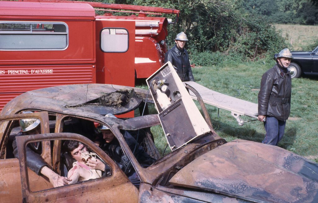 Pompiers secourant blessé dans voiture incendiée