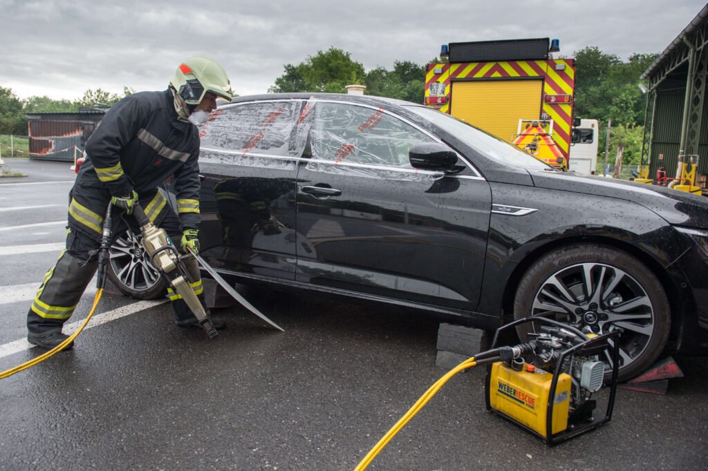 Pompiers désincarcérant une voiture accidentée sous la pluie