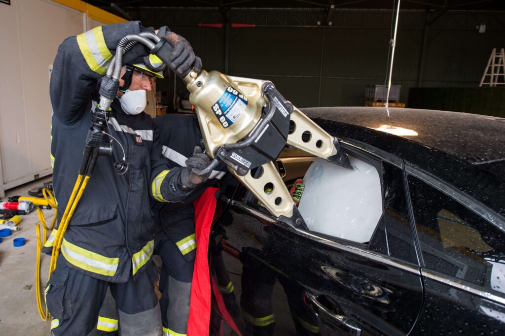 Pompiers équipés préparant leur matériel dans un véhicule